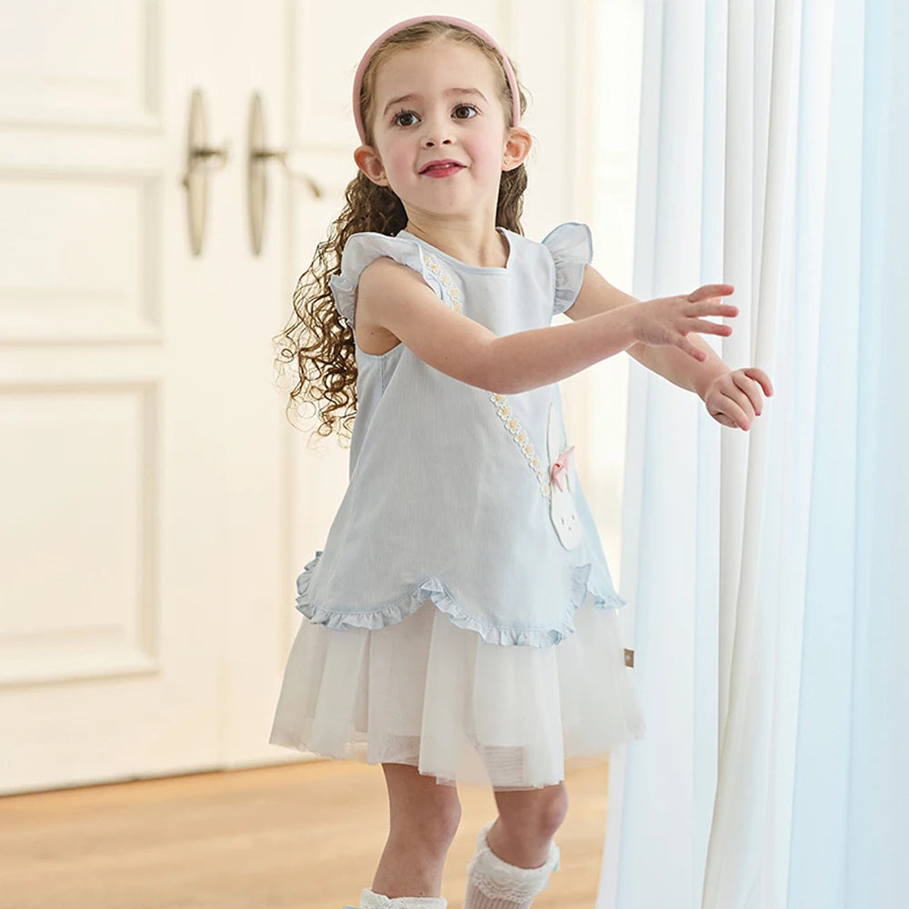 Girl wearing pale blue bunny party dress, three-quarter view
