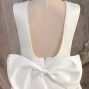 Deep scoop back and oversized bow detail on white dress