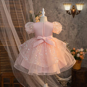Pink girls party dress with back bow and puff sleeves, rear view