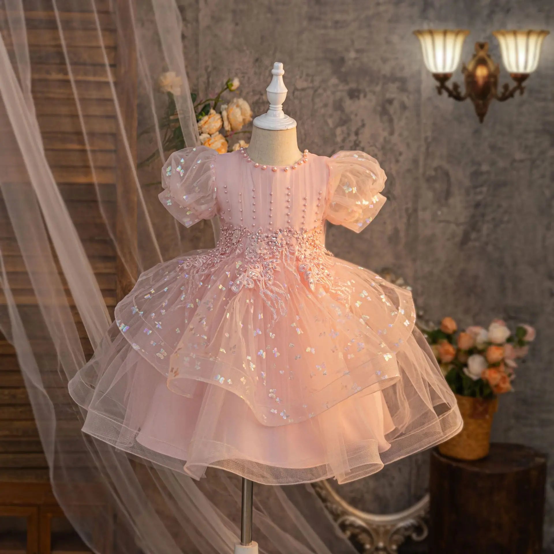 Pink girls party dress with puff sleeves, embroidered bodice and layered skirt, front view
