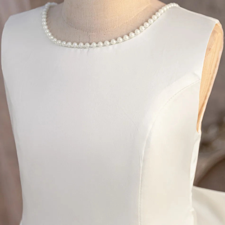 Pearl-look neckline detail on white flower girl dress