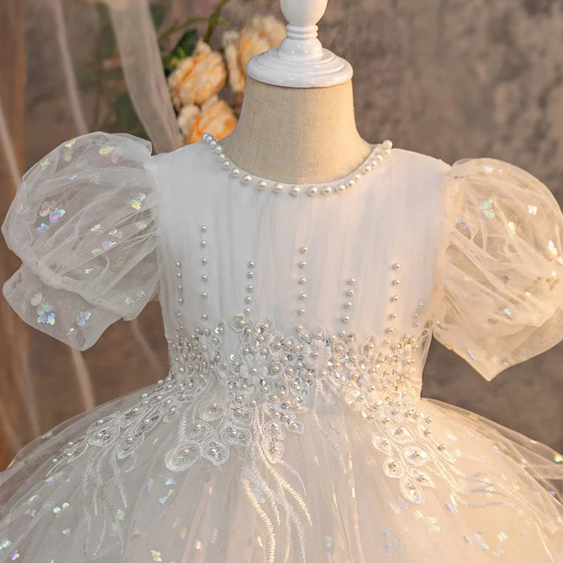 White girls party dress with pearl-like accents and embroidered waist, close-up