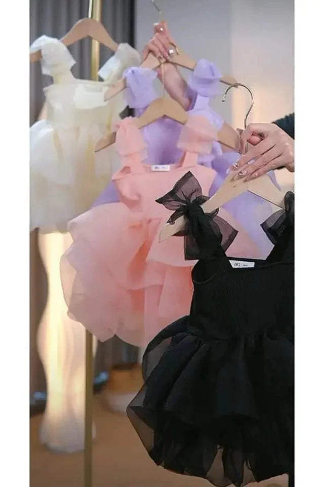 Babelio pastel and black toddler princess dresses on hangers in a well-lit room