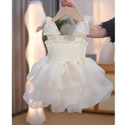Babelio baby white princess dress with ruffled skirt on hanger in modern bedroom