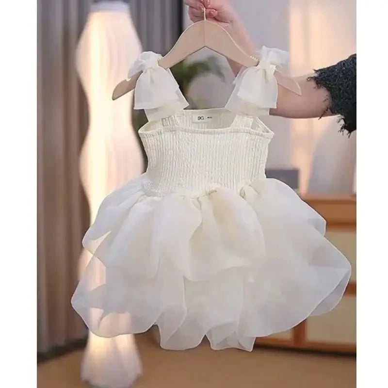 Babelio baby white princess dress with ruffled skirt on hanger in modern bedroom