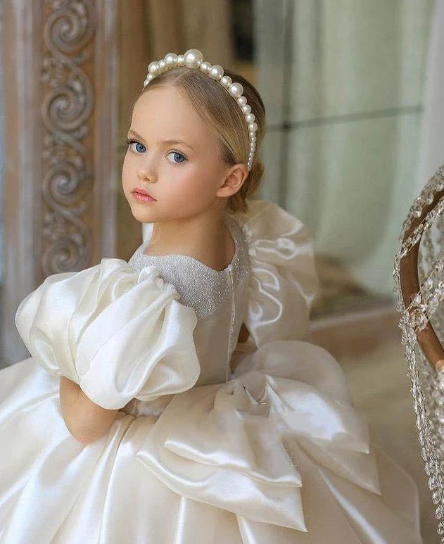 Babelio girl in white puffy dress with pearl headband in elegant indoor setting