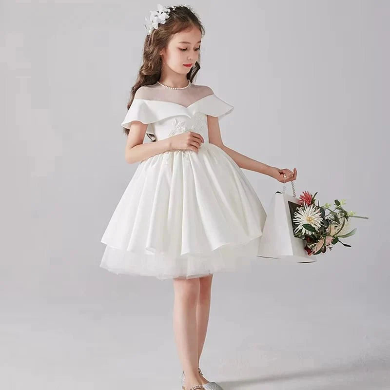 Babelio elegant flower girl in white dress with floral headband, standing indoors