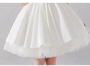Babelio white flower girl dress with layered skirt in formal studio setting