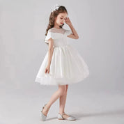 Babelio flower girl in elegant white dress with floral headpiece and sparkling shoes